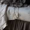 Mathilde Bundle — Limited Release | Close up of blanket and crib sheet showcases the muted floral pattern of the linen and the satin trim detail.