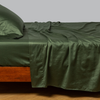 Bria Twin Flat Sheet | Juniper | Cotton sateen flat sheet, shown with matching fitted sheet and sleeping pillow - side view.