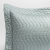Cirillo Throw Pillow | Eucalyptus | a close up of a pillow corner showing the flange framing quilted cotton sateen shot against a white background.