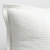Cirillo Throw Pillow | Winter White | a close up of a pillow corner showing the flange framing quilted cotton sateen shot against a white background.