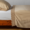 Madera Luxe Pillowcase (Single) | Honeycomb | matching tencel pillowcase and flat sheet trimmed with cotton lace on a bed shown from the side view.