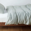 Austin Duvet Cover | Eucalyptus | Midweight linen duvet cover in eucalyptus on a bed, side view.