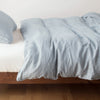 Austin Duvet Cover | Mineral | Midweight linen duvet cover in mineral on a bed, side view.
