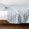Austin Coverlet | Cloud | Quilted midweight linen coverlet in cloud on a bed - side view.