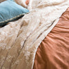 Lynette Blanket | Close-up of rumpled Lynette throw blanket in pearl, layered with rich pink and pale blue silk velvet.