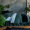 Cirillo Twin Coverlet | a twin bed shown from the side dressed mostly in monochromatic tones, the flat sheet is folded back over the duvet cover which is pulled back over the coverlet and folded throw blanket at the foot of the bed.