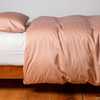 Bria Twin Duvet Cover | Rouge | duvet cover and matching sleeping pillow on white sheeting - side view.