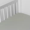 Bria Crib Sheet | Eucalyptus | Cotton sateen crib sheet shown from a slight overhead angle into  an inside corner of a crib.