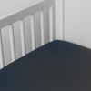 Bria Crib Sheet | Midnight | Cotton sateen crib sheet shown from a slight overhead angle into  an inside corner of a crib.