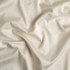 Bria Crib Sheet | Parchment | A close up of cotton sateen fabric in parchment, a warm, antiqued cream.