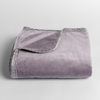 Harlow Baby Blanket | French Lavender | cotton velvet baby blanket trimmed with charmeuse, folded with a corner folded back to show trim contrast; shot overhead at a slight angle against a white background.