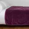 Harlow Blanket | Fig | Cotton velvet bed end sized  blanket, draped on a white bed - side view.