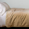 Harlow Blanket | Honeycomb | Cotton velvet bed end sized blanket, draped on a white bed - side view.