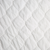 Harlow Coverlet | Winter White | A close up of quilted cotton velvet fabric in winter white, softer and warmer in tone than classic white.