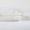 Ines Throw Pillow | Winter White | Close-up of brass zipper and charmeuse pull details on throw pillow - side view.