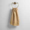 Ines Guest Towel | Honeycomb | guest towel draped through a decorative brass towel ring against a white background.