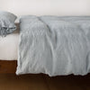 Ines Duvet Cover | Mineral | lightly rumpled duvet cover on a monochromatic bed against a white background - side view.