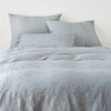 Ines Duvet Cover | Mineral | duvet cover and matching shams against a white wall - end of bed view.