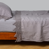 Linen Flat Sheet | French Lavender | lace trimmed flat sheet shown with monochromatic bedding - side view.