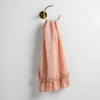 Linen Whisper Guest Towel | Rouge | guest towel draped through a decorative brass towel ring, against a white wall.