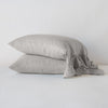 Linen Whisper Pillowcase (Single) | Two Linen Whisper sleeping pillows, stacked at a slight angle against a plain background, showcasing ruffle trim detail - fog, side view.