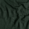 Linen Crib Skirt | Juniper | A close up of linen fabric in Juniper, a deep green tone.
