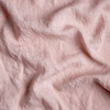 Linen Bed Skirt | Rouge | A close up of linen fabric in rouge, a mid-tone blush pink.