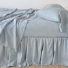 Linen Bed Skirt | Mineral | bed skirt with matching rumpled sheets and sleeping pillows - side view.