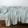 Linen Fitted Sheet | Eucalyptus | fitted sheet with matching rumpled flat sheet and sleeping pillow - side view.