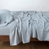 Linen Fitted Sheet | Mineral | fitted sheet with matching rumpled flat sheet and sleeping pillow - side view.
