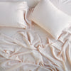 Linen Fitted Sheet | Pearl | fitted sheet with matching rumpled flat sheet and sleeping pillows - overhead view.