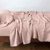 Linen Fitted Sheet | Rouge | fitted sheet with matching rumpled flat sheet and sleeping pillow - side view.