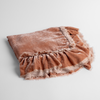 Loulah Baby Blanket | Rouge | an overhead shot of a folded silk velvet baby blanket with a raw-edged eyelash ruffle detail.