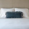 Loulah Throw Pillow | Mineral | pillow on a white bed - cropped end of bed view.