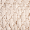 Luna Coverlet | Pearl | A close up of quilted charmeuse fabric in pearl, a nude-like, soft rose pink tone.