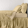 Luna Coverlet | Honeycomb | coverlet neatly folded back to reveal linen reverse, on a monochromatic bed - side view.