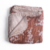 Lynette Blanket | Rouge | overhead angle of the folded blanket with a corner pulled back to show the reverse and trim.