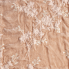 Lynette Blanket | Pearl | A close up of embroidered silk velvet fabric in pearl, a nude-like, soft rose pink tone.