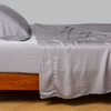 Madera Luxe Fitted Sheet | French Lavender | tencel™ fitted sheet with matching flat sheet and sleeping pillow from the madera luxe collection - side view.