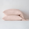 Madera Luxe Pillowcase (Single) | Rouge | sleeping pillows stacked neatly against a white backdrop - side view.