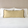 Paloma Throw Pillow | Honeycomb | 16x36 charmeuse pllow wth silk velvet trim against white sleeping pillows and sheets — straight on with neutral background.