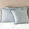 Paloma Sham | Mineral | shams leaning upright on white sheeting against a neutral headboard.
