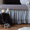 Silk Velvet Quilted Baby Blanket | Blanket in moonlight folded and draped over a basket in blue and grey nursery scene, shown with stuffed animals and wooden elephant pull toy.