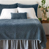 Silk Velvet Quilted Twin Coverlet | Mineral | coverlet and matching shams on a neatly made, white bed - end of bed view.