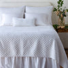 Silk Velvet Quilted Twin Coverlet | White | coverlet and matching shams on a neatly made, white bed - end of bed view.