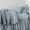 Silk Velvet Quilted Throw Pillow | Cloud | 16x36 pillow with rumpled matching coverlet on monochromatic bed - side view.