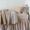 Silk Velvet Quilted Throw Pillow | Pearl | 16x36 pillow with rumpled matching coverlet on monochromatic bed - side view.