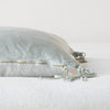 Taline Throw Pillow | Cloud | Close-up side vew featuring brass zipper with charmeuse pull and linen back.