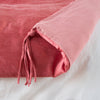 Taline Blanket | Poppy | Close up of blanket, with a corner turned back to showcase the midweight linen back and corner tassel - overhead view.