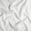 Madera Luxe Twin Flat Sheet | Winter White | A close up of tencel™ fabric in winter white, softer and warmer in tone than classic white.